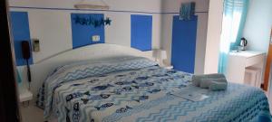 una camera con un letto e un piumone blu e bianco di Hotel VILLA ITALIA a Porto Azzurro
