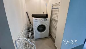 a washing machine in a laundry room with a basket at Rare Holiday Homes presents Large 1 Bed in a peaceful community of JVC -La Riviera Estate B R106 in Dubai