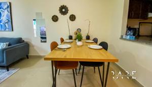 a wooden table in a living room with chairs at Rare Holiday Homes presents Large 1 Bed in a peaceful community of JVC -La Riviera Estate B R106 in Dubai