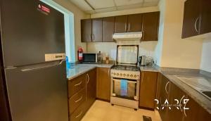 a kitchen with a stainless steel refrigerator and a stove at Rare Holiday Homes presents Large 1 Bed in a peaceful community of JVC -La Riviera Estate B R106 in Dubai