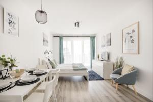 un soggiorno bianco con tavolo e sedie bianchi di Modern Riverfront Apartment with Free Parking a Budapest