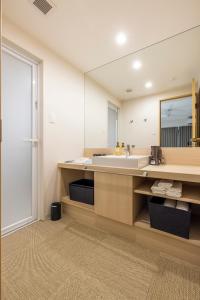uma casa de banho com um lavatório e um espelho em アルファベットイン那覇国際通りWEST em Tsuboya