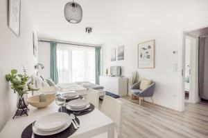 un soggiorno bianco con tavolo e divano di Modern Riverfront Apartment with Free Parking a Budapest