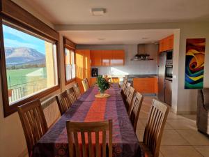 a dining room with a table and chairs and a kitchen at Casa rural Navarra para niños, accesible para grupos grandes de 14-16 personas Belastegui II in Eulz