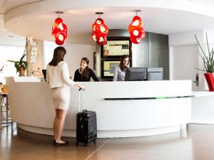 馬賽的住宿－馬賽歐洲地中海中心諾富特套房酒店，办公室柜台的三名妇女