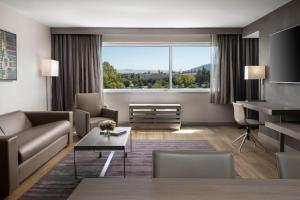 a living room with a couch and a table at AC Hotel by Marriott Pleasanton in Pleasanton