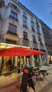 a building with a red umbrella in front of it at HOTEL de la POSTE in Esch-sur-Alzette +27 photos