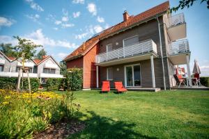a house with orange chairs in the yard at Panorama_Apartment 1 P6 optional P in Plau am See