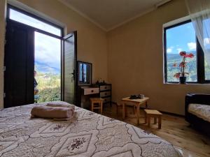 um quarto com uma cama grande e uma janela grande em Bela's Guesthouse em Mestia