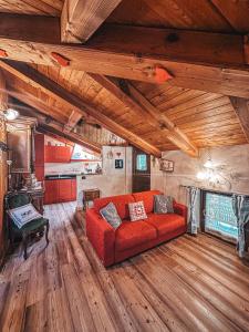 uma sala de estar com um sofá vermelho e pisos em madeira em La Maison de Julie em Pré-Saint-Didier