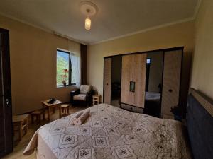 a bedroom with a large bed and a chair at Bela's Guesthouse in Mestia