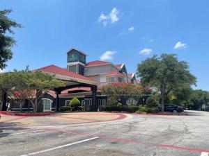 a parking lot in front of a building with a clock tower at La Quinta by Wyndham Dallas Arlington South in Arlington