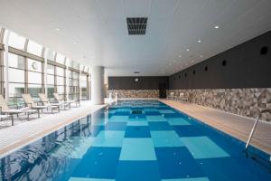 a large swimming pool with blue tiles in a building at Hilton Nagoya Hotel in Nagoya