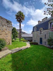 a palm tree in the yard of a house at Appartement d'exception - proche de la mer in Saint-Brieuc