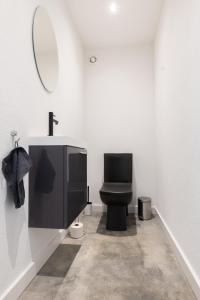 a bathroom with a black toilet and a mirror at Haus Paul in Kals am Großglockner