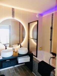 a bathroom with two sinks and a large mirror at La Boucle des Molliers in Cenves