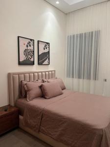 - un lit dans une chambre avec 3 photos sur le mur dans l'établissement Impeccable 2-Bed Rooms Apartment in Casablanca, à Casablanca