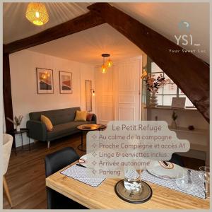 uma sala de estar com uma mesa e um sofá em Le Petit Refuge par Your Sweet Loc em Le Meux