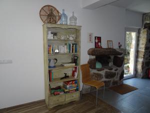 een boekenplank met boeken en een stoel in een kamer bij A CASA COM 2 PEREIRAS in Terras de Bouro