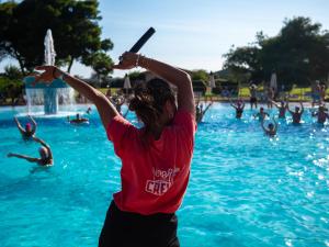 a woman holding a baseball bat in a swimming pool at Gitavillage California in Montalto di Castro