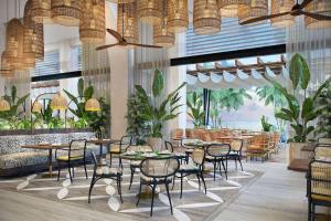 un ristorante con tavoli, sedie e piante di Canopy By Hilton Seychelles a Anse a La Mouche