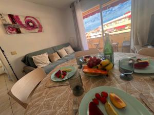 Una mesa con platos de fruta en una sala de estar. en Jardín, en Puerto de Santiago