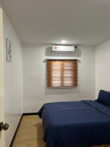 a bedroom with a blue bed and a window at The Garden House Lahad Datu in Lahad Datu