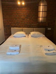 a large white bed with towels on top of it at Pokoje Gościnne Atelier in Orneta