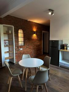 a kitchen with a table and chairs and a brick wall at Pokoje Gościnne Atelier in Orneta