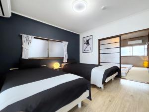 1 dormitorio con 2 camas y ventana en guesthouse築港, en Osaka