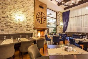 a restaurant with tables and chairs and a clock on the wall at Pirin Bliss Apartment Ski, Spa and Relax at Terra Complex in Razlog