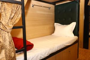 a bed in a bunk bedded room with a pillow and a ladder at Dormitory Hub in Mumbai