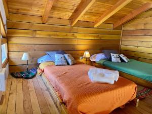 um quarto com duas camas num chalé de madeira em Alewekehue departamento em San Carlos de Bariloche