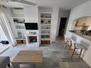 a kitchen and living room with a table and chairs at Apt Erisa en Torremolinos dos min de la playa, Puerto Marina in Torremolinos