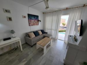 a living room with a couch and a table at Apt Erisa en Torremolinos dos min de la playa, Puerto Marina in Torremolinos