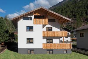 un edificio blanco con balcones de madera en Haus Paul, en Kals am Großglockner