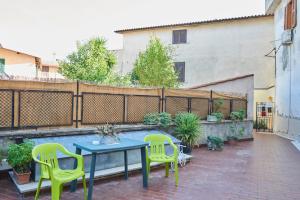 a patio with a table and chairs and a fence at Jerry & Titty house in Capena