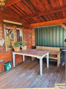 a wooden porch with a table and two benches at Op e Mieden in Bartlehiem