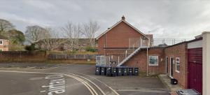 a brick building with a staircase on the side of it at Large Apartment Near Stonehenge Amesbury Town Centre Smart TVs Netflix FREE PARKING in Amesbury