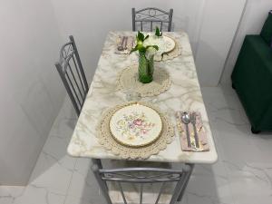 un tavolo bianco con piatti e un vaso sopra di Casa Concetta Resort a Manolo Fortich