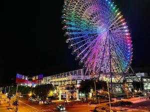 Una gran rueda de la fortuna se ilumina por la noche en guesthouse築港, en Osaka