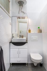 V26 Freedom Lodge Apartment في بودابست: حمام أبيض مع حوض ومرحاض