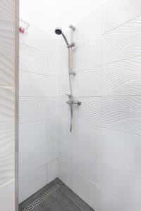 um chuveiro numa casa de banho em azulejos brancos em V26 Freedom Lodge Apartment em Budapeste