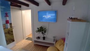 sala de estar con TV en la pared en Feierabend im Grünen, en Haan