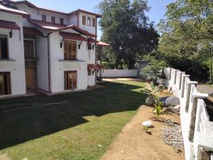 a house with a fence and a yard at Rose Cottage in Digana
