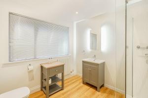 a bathroom with a toilet and a sink and a shower at Peregrine Cottage with Hot Tub in Newton Stewart +17 photos