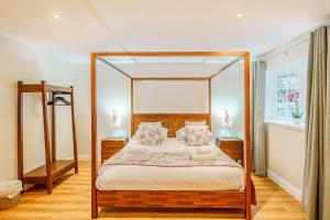 a bedroom with a large bed with a wooden frame at Peregrine Cottage with Hot Tub in Newton Stewart