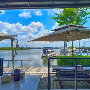 a picnic table with an umbrella and a marina at 5min Mid Valley Southkey 10min KSL CIQ City Square in Johor Bahru