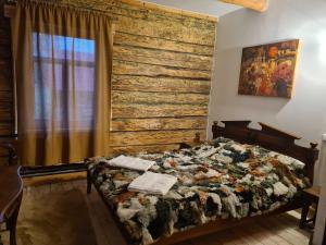 a bedroom with a bed and a wooden wall at Zirgu sēta "Klajumi" - Horse ranch "Klajumi" in Kaplava