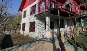 een oud huis met een rood en wit bij OYO Flagship 4945 AR LODGE in Srinagar